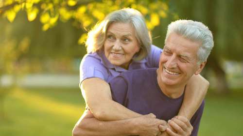 An elderly couple smiling after getting gum disease treatment in Windsor, NSW